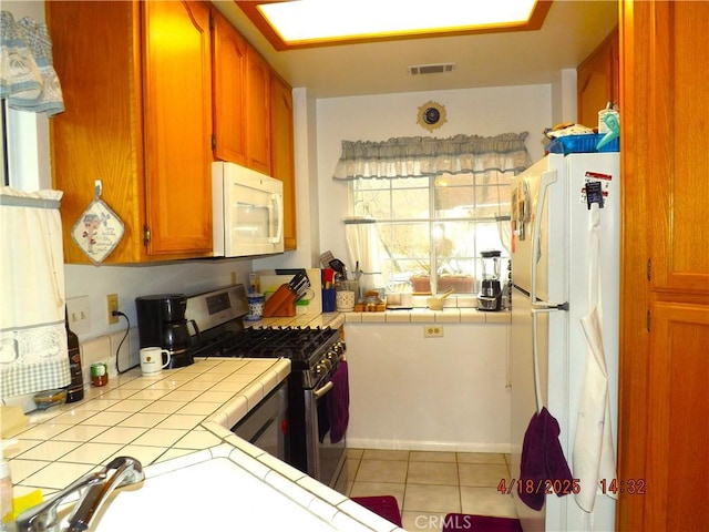 848 Oakmont, Lake Arrowhead, CA 92352 - kitchen featuring white appliances, tile counters, brown cabinets, and light tile patterned flooring