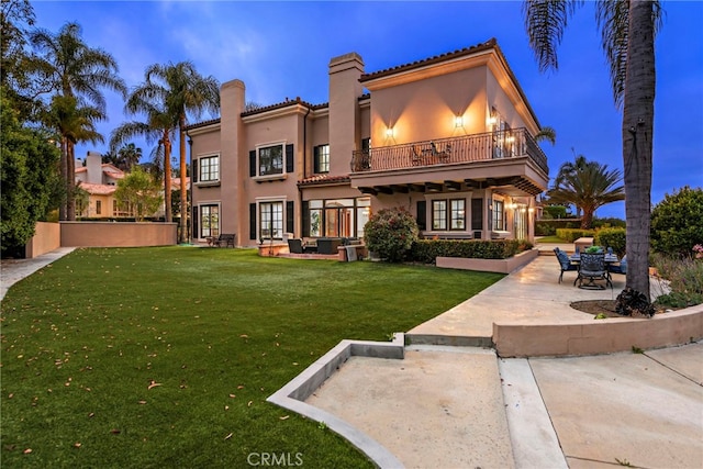 6 Riverstone, Laguna Niguel, CA 92677 - rear view of house with a chimney, a balcony, stucco siding, a patio area, and a lawn