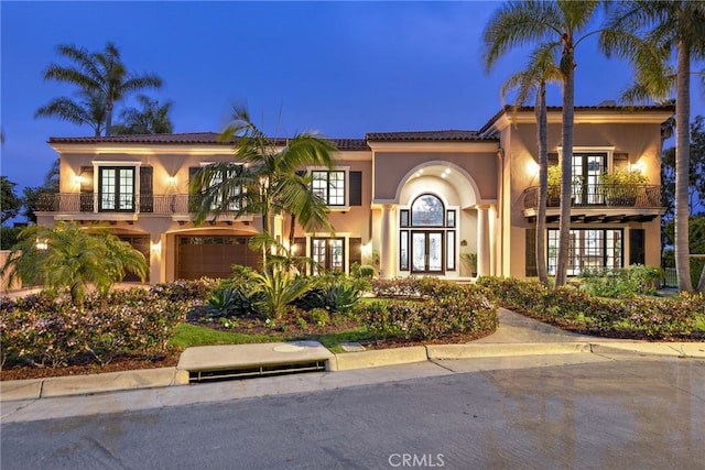 6 Riverstone, Laguna Niguel, CA 92677 - mediterranean / spanish house featuring an attached garage, french doors, a balcony, and stucco siding
