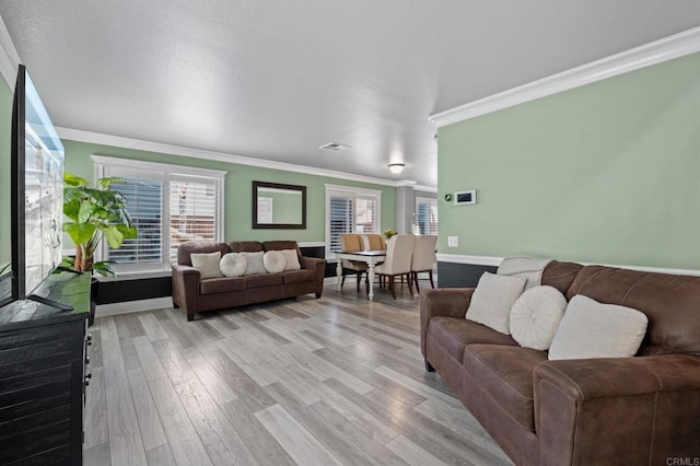 living room featuring light wood-style flooring, baseboards, and ornamental molding