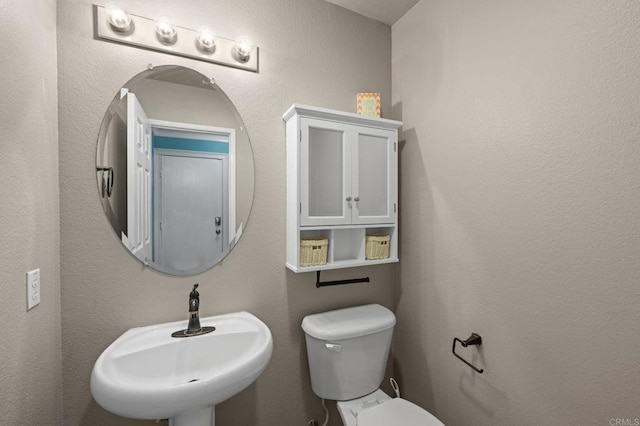 half bathroom with toilet and a sink