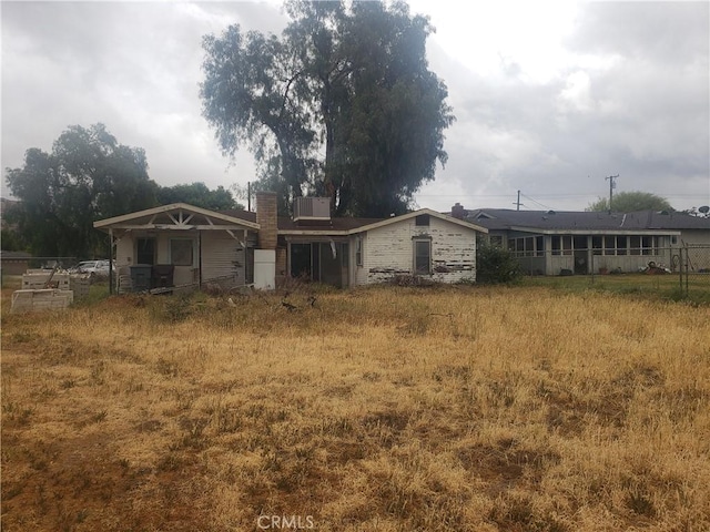 rear view of property featuring a chimney