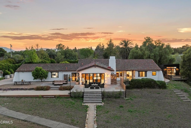 1270 Dove Meadow Rd, Solvang, CA 93463 - view of front of house featuring a tile roof, an outdoor hangout area, a patio, stucco siding, and a chimney