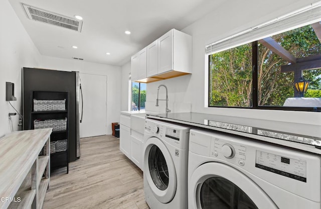 1270 Dove Meadow Rd, Solvang, CA 93463 - washroom with washing machine and dryer, light wood finished floors, plenty of natural light, recessed lighting, and cabinet space
