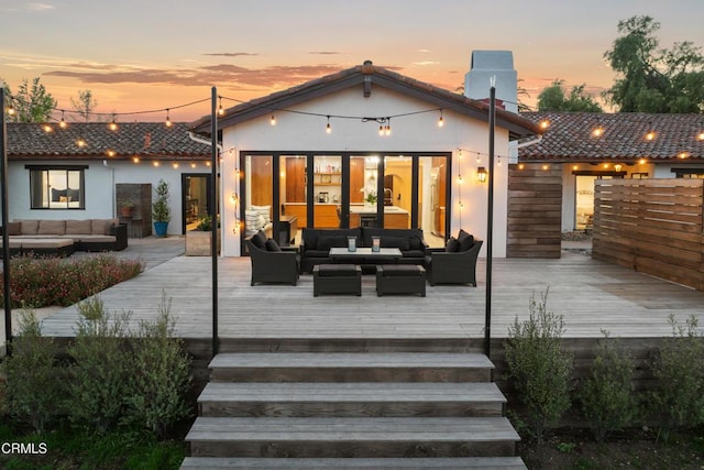 1270 Dove Meadow Rd, Solvang, CA 93463 - back of property at dusk with outdoor lounge area, a deck, a tiled roof, and stucco siding