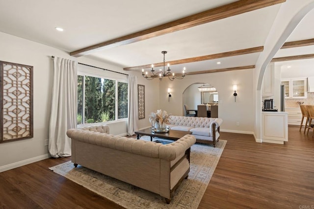 living room featuring dark wood finished floors, arched walkways, beam ceiling, and baseboards