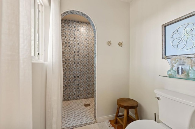 bathroom with toilet and a tile shower
