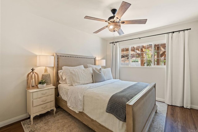 bedroom featuring wood finished floors, a ceiling fan, and baseboards