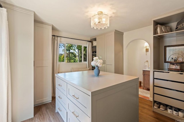 spacious closet featuring light wood finished floors and a chandelier