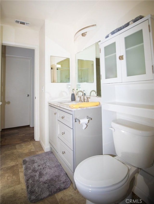 272 Rio Bravo Ct, Corning, CA 96021 - bathroom featuring toilet, stone finish floor, vanity, and visible vents
