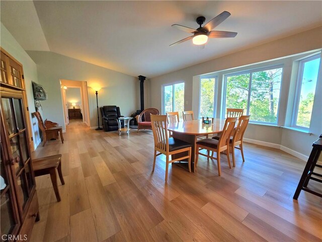 47180 Lookout Mountain Dr, Coarsegold, CA 93614 - dining room with a wood stove, lofted ceiling, light wood-type flooring, a ceiling fan, and baseboards