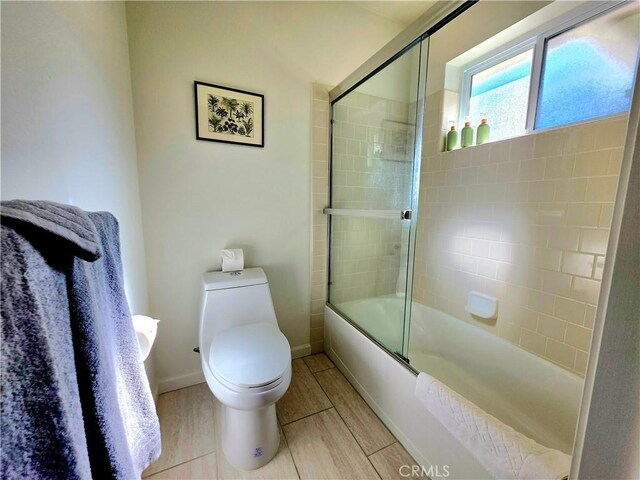47180 Lookout Mountain Dr, Coarsegold, CA 93614 - bathroom featuring toilet, bath / shower combo with glass door, and baseboards