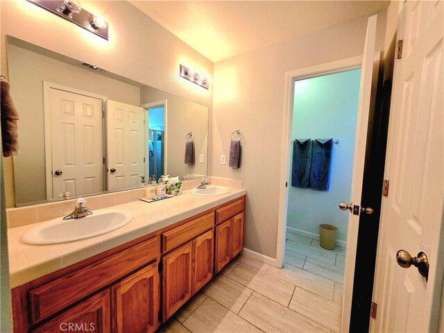 47180 Lookout Mountain Dr, Coarsegold, CA 93614 - full bathroom with double vanity, baseboards, and tile patterned floors