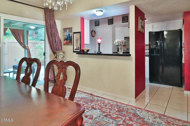 dining room featuring light tile patterned floors, a chandelier, baseboards, and a textured ceiling