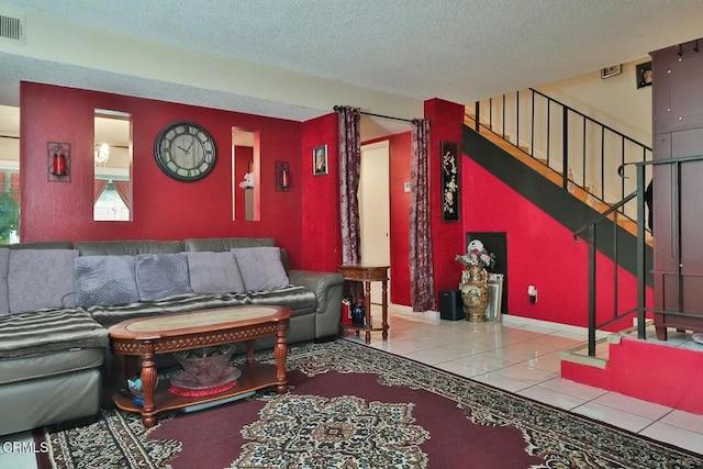 tiled living area featuring a textured ceiling, stairway, and baseboards