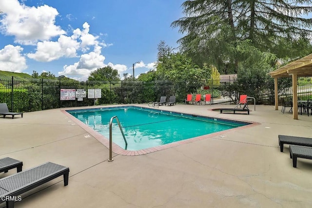 community pool featuring fence and a patio