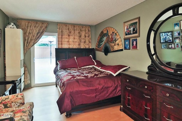 bedroom with a textured ceiling and wood finished floors