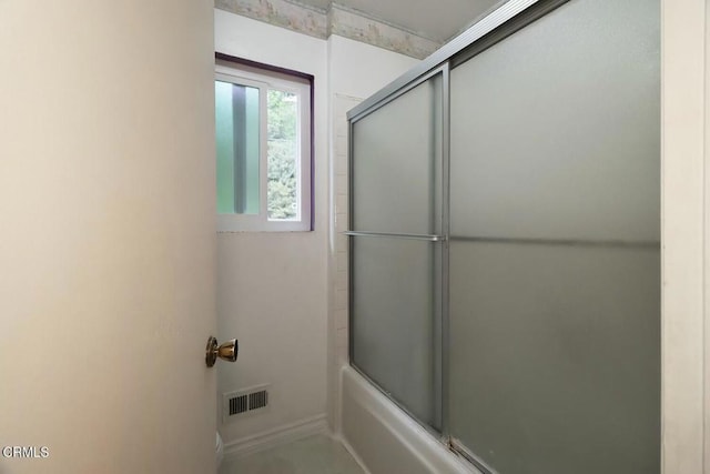 full bathroom featuring shower / bath combination with glass door and baseboards
