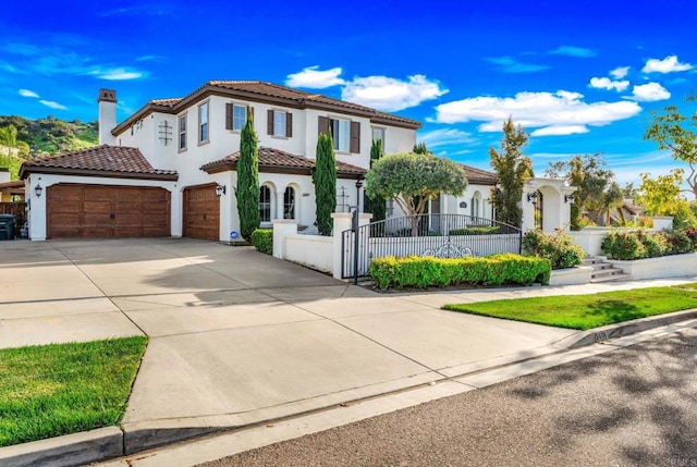 mediterranean / spanish-style house with a fenced front yard, driveway, a tiled roof, a garage, and stucco siding