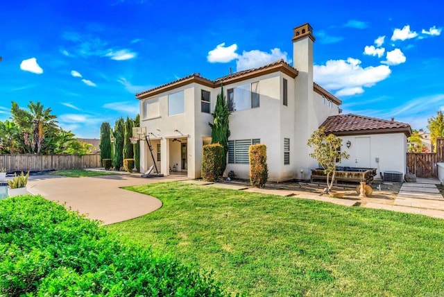 back of house featuring stucco siding, a lawn, fence, and a patio