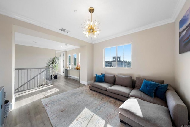 living area featuring ornamental molding, baseboards, a notable chandelier, and wood finished floors