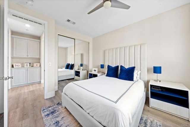 bedroom with baseboards, visible vents, light wood-style floors, a ceiling fan, and a closet