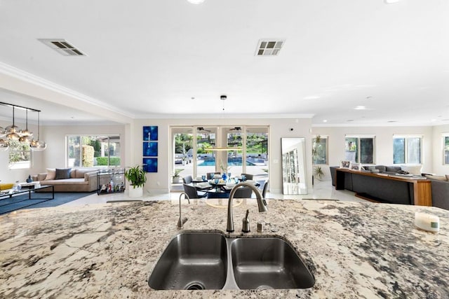 kitchen featuring open floor plan, visible vents, a sink, and crown molding
