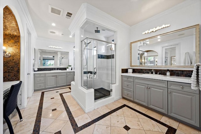 bathroom featuring two vanities, crown molding, a stall shower, and a sink