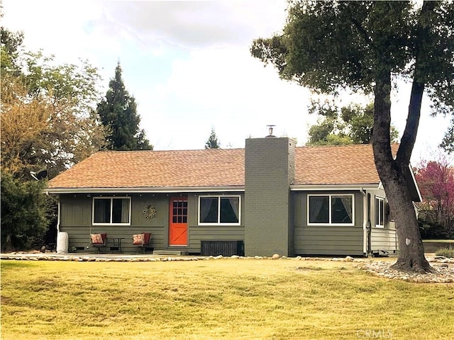 single story home featuring a chimney, a front lawn, and roof with shingles