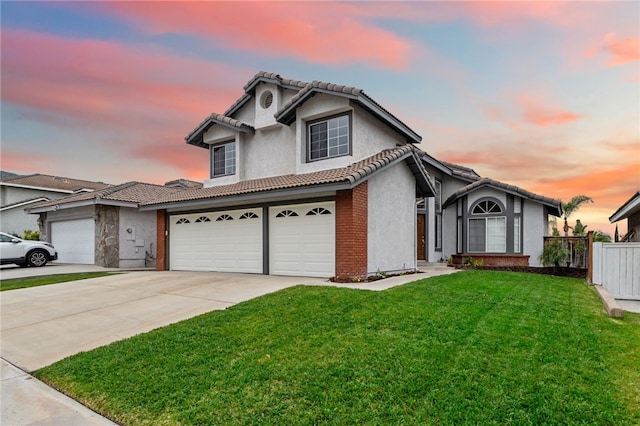 traditional-style home featuring fence, a front yard, stucco siding, concrete driveway, and a tile roof