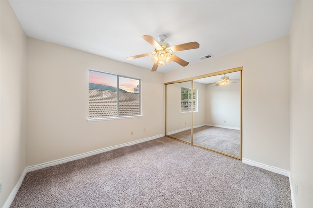 unfurnished bedroom featuring carpet flooring, baseboards, visible vents, and a closet