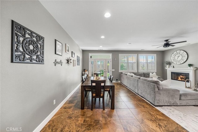 dining area featuring recessed lighting, dark tile patterned floors, ceiling fan, a glass covered fireplace, and baseboards