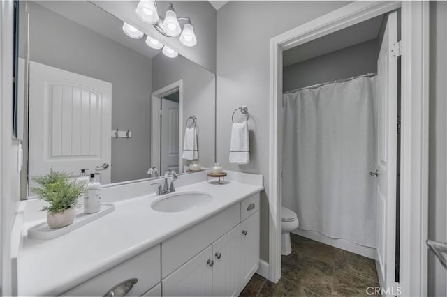 bathroom with curtained shower, toilet, stone finish floor, and vanity