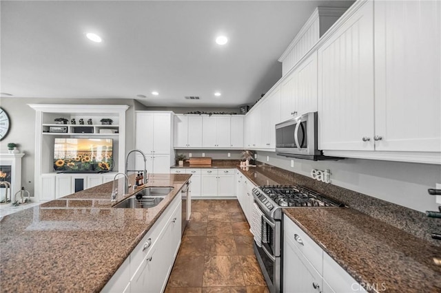 kitchen featuring recessed lighting, a sink, stainless steel appliances, visible vents, and white cabinetry