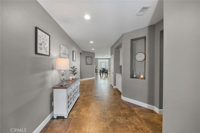 corridor with visible vents, recessed lighting, and baseboards