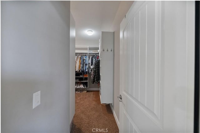 hall featuring baseboards and carpet