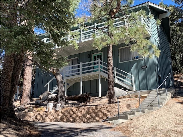 33010 Juniper Ln, Green Valley Lake, CA 92341 - rear view of property featuring a balcony, board and batten siding, and stairway