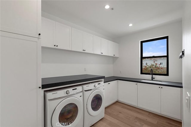 laundry area featuring recessed lighting, a sink, washing machine and dryer, light wood-type flooring, and cabinet space