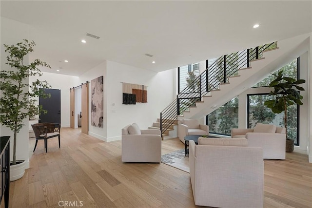 living room with light wood finished floors, stairs, visible vents, and recessed lighting