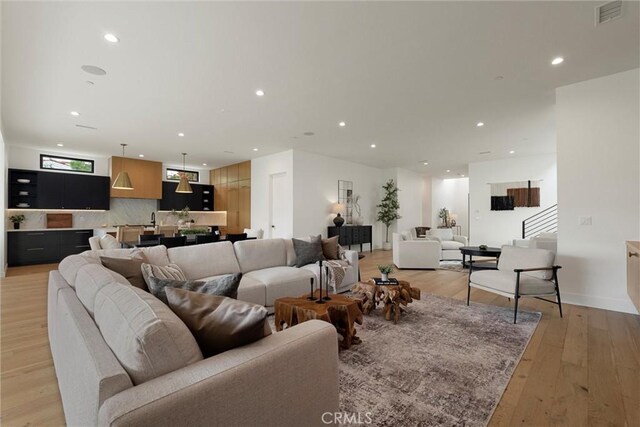 living area featuring light wood finished floors, visible vents, and recessed lighting