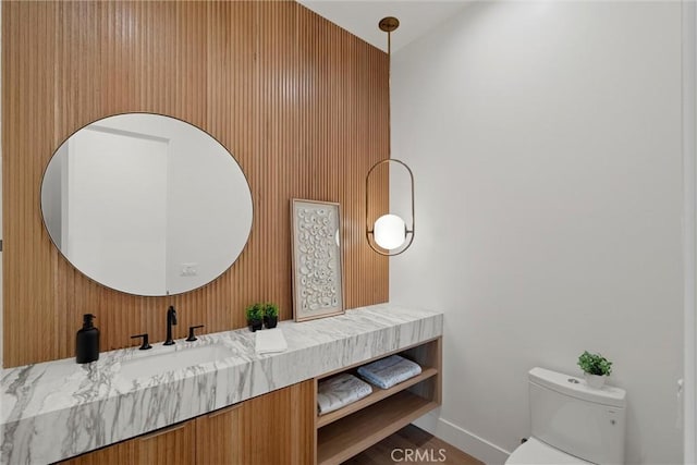 bathroom featuring vanity, toilet, and baseboards