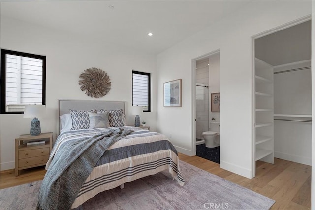 bedroom featuring recessed lighting, light wood-style floors, ensuite bath, and baseboards
