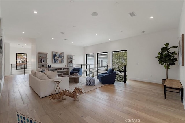 living area with recessed lighting, an inviting chandelier, visible vents, light wood-type flooring, and baseboards