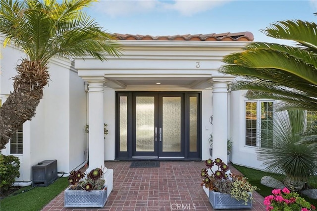 property entrance featuring central air condition unit, french doors, and stucco siding