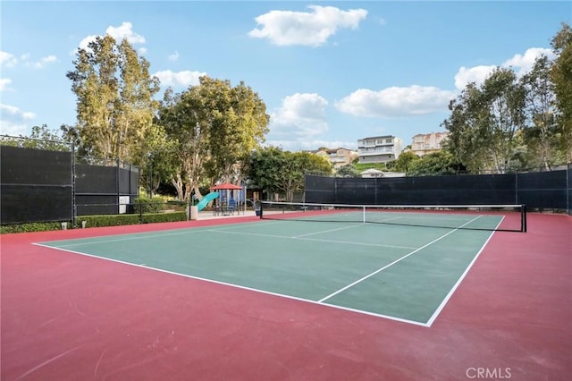 view of sport court with community basketball court, fence, and playground community
