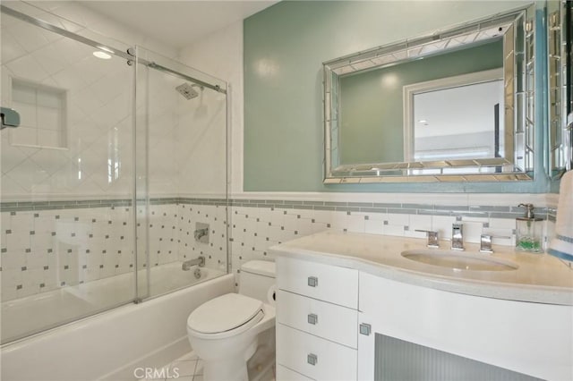 full bath featuring vanity, toilet, tile patterned floors, enclosed tub / shower combo, and tile walls