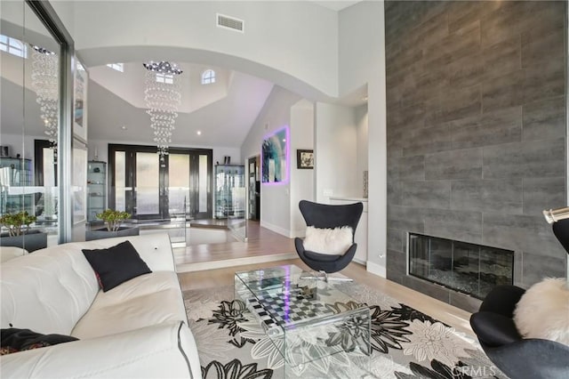 3 Via Pasa, San Clemente, CA 92673 - living area with arched walkways, wood finished floors, a chandelier, a tile fireplace, and high vaulted ceiling
