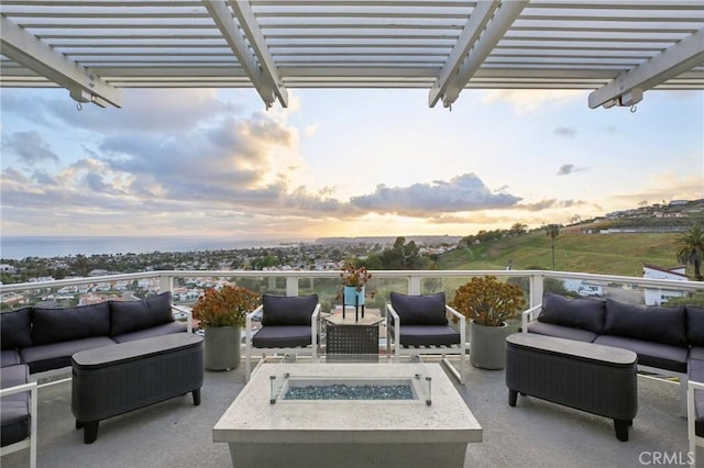 patio terrace at dusk with an outdoor living space with a fire pit and a pergola