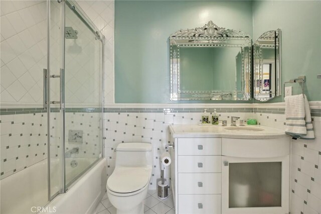 3 Via Pasa, San Clemente, CA 92673 - full bathroom with combined bath / shower with glass door, vanity, tile walls, wainscoting, and tile patterned flooring