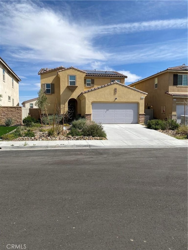 13110 Rosamond Ct, Hesperia, CA 92395 - mediterranean / spanish-style home with stucco siding, driveway, a garage, a tile roof, and roof mounted solar panels